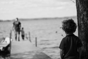 Grayscale photograph of child beside tree